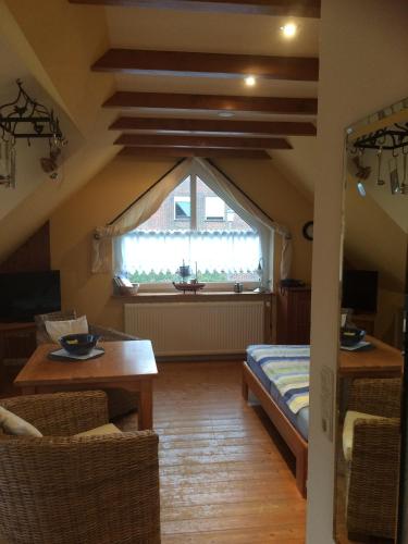 a attic room with a table and a window at Hus Nordhauk in Borkum