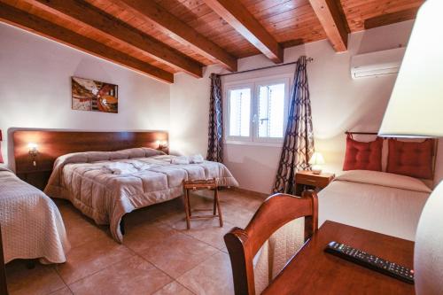 a bedroom with two beds and a table and a desk at Villa Margherita in Sciacca