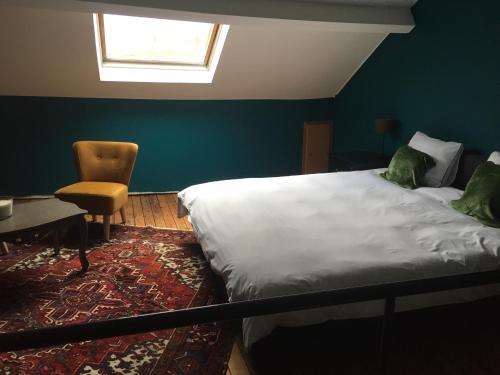 1 dormitorio con 1 cama, 1 silla y 1 ventana en Jules en ville 1, en Bastogne