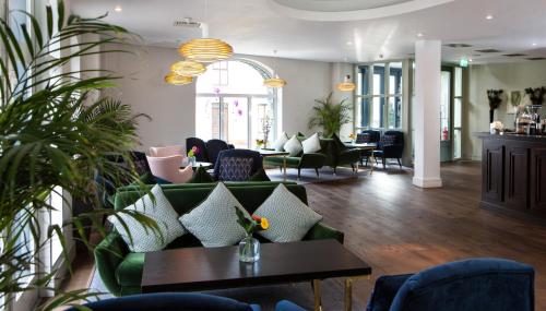 a living room with a green couch and chairs at The House Hotel, an Ascend Hotel Collection Member in Galway