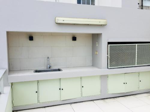 een keuken met witte kasten en een spoelbak bij Soho Luxury Loft in Buenos Aires