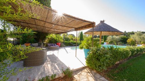 une terrasse avec un grand parasol et quelques plantes dans l'établissement Villa d Agathe en Provence Graveson, à Graveson
