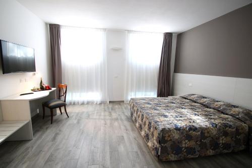 a hotel room with a bed and a desk and window at Resilienza in Mira