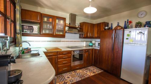 a kitchen with wooden cabinets and a white refrigerator at Villa Ana in Costa Teguise