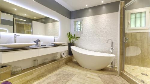 La salle de bains est pourvue de 2 lavabos et d'une grande baignoire. dans l'établissement Villa d Agathe en Provence Graveson, à Graveson