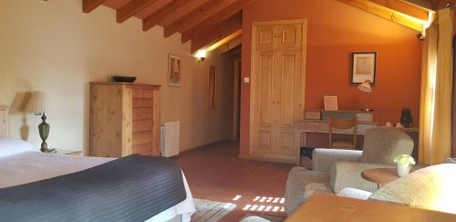 a living room with a bed and a desk in a room at Hotel Sara De Ur in La Cabrera