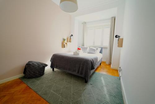 a bedroom with a bed with a green rug at Avenidas Cozy Apartment in Lisbon