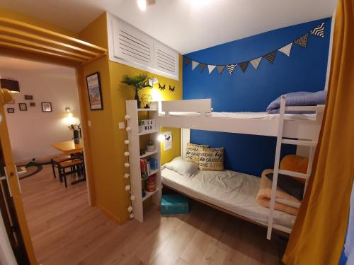 a room with two bunk beds and a dining room at L'Appart' à la Mer in La Guérinière