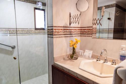 a bathroom with a sink and a shower at Hotel Casa Laureles in Medellín