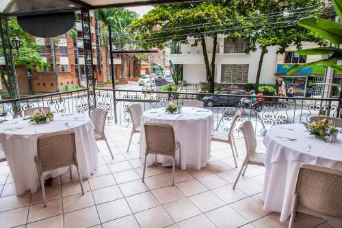 a dining area with tables, chairs and umbrellas at Hotel Casa Laureles in Medellín