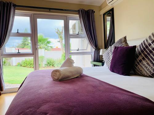 a bedroom with a bed with a stuffed animal on it at Resthaven Guest House in Mthatha