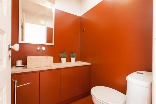 リスボンにあるFLH Se Cozy Flatのオレンジ色のバスルーム(トイレ、シンク付)