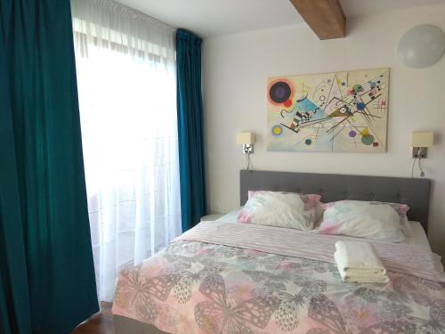 a bedroom with a bed with blue curtains and a window at Podzamcze in Rożnów