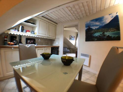 een keuken met een tafel met twee kommen erop bij Logement atypique avec vue unique panoramique sur le lac d’Annecy, dans une résidence avec plage et ponton privée sur la commune de Duingt (Rive gauche du lac). in Duingt