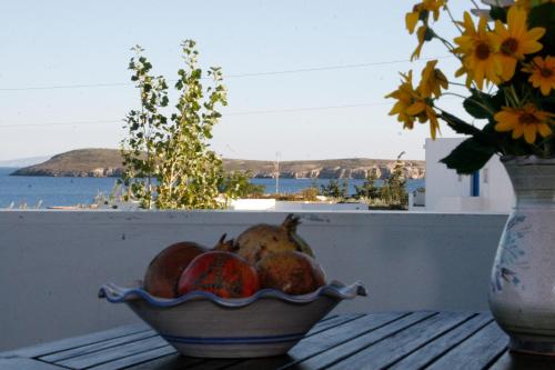 a bowl of fruit on a table with a vase of flowers at Nefeli in Drios