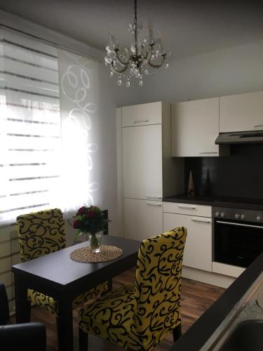 a kitchen with a table and chairs and a chandelier at Apartment Elfi in Leibnitz