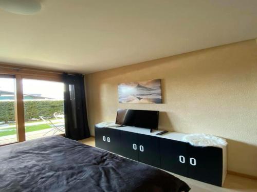 a bedroom with a bed and a large window at Apartment with Garden Daltons 1 in Crans-Montana