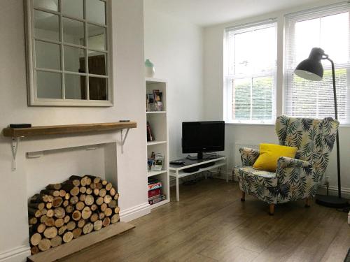 a living room with a fireplace and a chair and a television at Number One in Wetherby