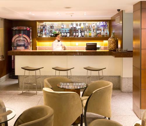 a man standing behind a bar in a restaurant at Mar Palace Copacabana Hotel in Rio de Janeiro