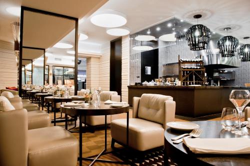 a restaurant with tables and chairs and a bar at Sofitel Warsaw Victoria in Warsaw