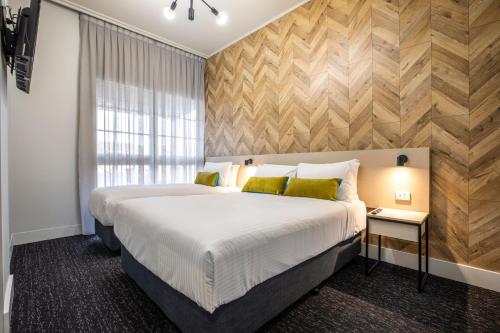 Nightcap at Sylvania Hotel في Campbellfield: غرفة نوم بسرير كبير ونافذة