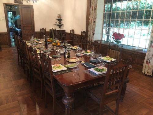 a dining room with a long wooden table and chairs at Casona Lo Aguirre , Hospedaje de Temporada Cálidas in Talagante