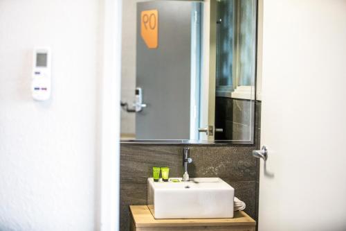 a bathroom with a white sink and a mirror at Nightcap at Sylvania Hotel in Campbellfield