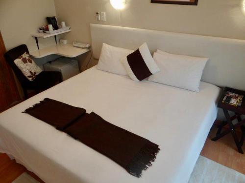 ein Schlafzimmer mit einem weißen Bett und einer schwarzen Decke darauf in der Unterkunft Lilliz Guest House in Mthatha