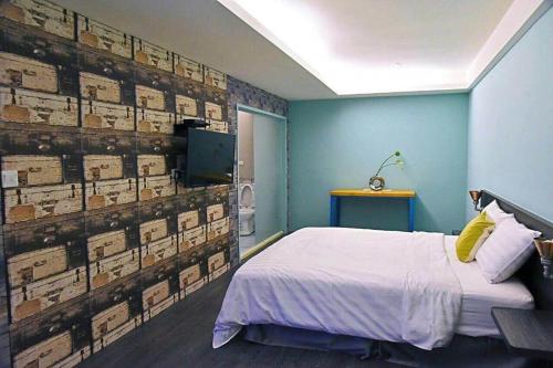 a bedroom with a bed and a wall with boxes at Tian Fang Ye Tan Hotel in Yilan City