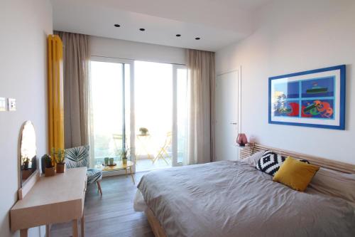 une chambre avec un grand lit, un bureau et une fenêtre dans l'établissement Seaview Apartments, à Palerme