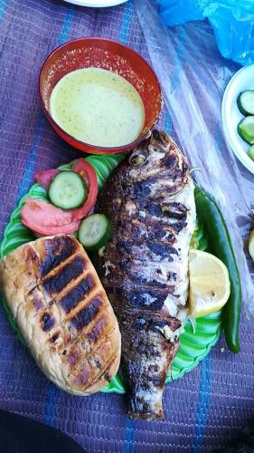 a plate of food with fish and vegetables on a table at Basant Villa in Wadi Musa