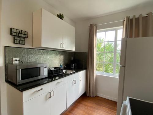a kitchen with white cabinets and a microwave at Harding Boutique Apartments in Miami Beach