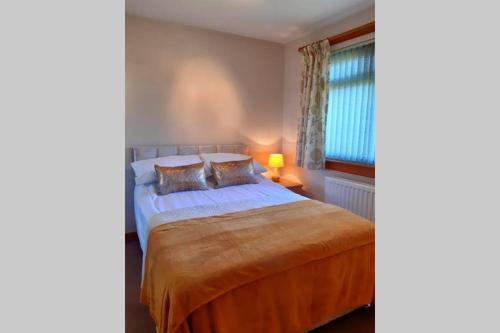 1 dormitorio con cama y ventana en Leafield Holiday Home en Stranraer