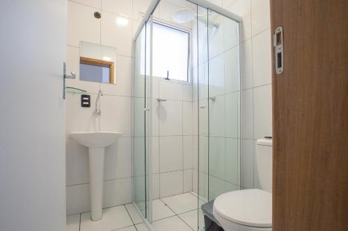 une salle de bains avec douche, toilettes et lavabo dans l'établissement Sun Way Apartamentos com piscinas e churrasqueiras, à Ubatuba