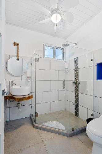 a bathroom with a glass shower and a sink at HOTEL MARINO BALLENA in Uvita
