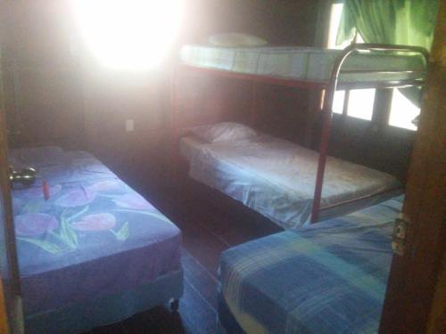 a bedroom with two bunk beds in a room at Hostal Villas Mexico in San Juan del Sur