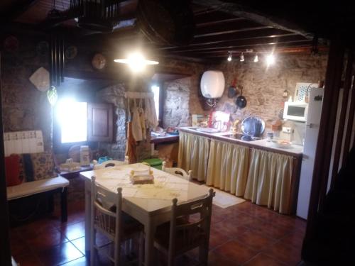 a kitchen with a table and a kitchen with a refrigerator at Ca'Pelayo in Campomanes