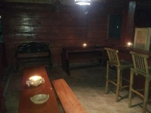 a living room with a table and chairs and a candle at Hostal Villas Mexico in San Juan del Sur