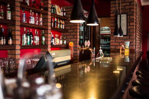 a bar with a counter with alcohol bottles at Zajazd Magnolia-Airport Modlin in Pomiechówek