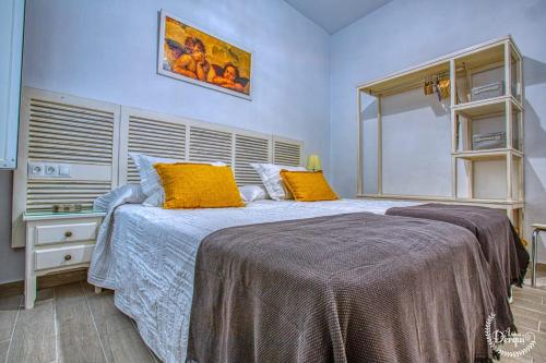 a bedroom with a large bed with yellow pillows at CASA ARCO DEL CAÑÓN - Casita con Encanto in Medina Sidonia