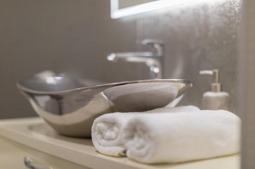 a sink and towels on a counter in a bathroom at Apartmani i sobe Pejačević in Osijek