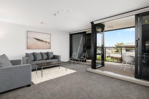 a living room with a couch and a table at Central Mount Apartment, Quiet and Spacious with Pool in Mount Maunganui