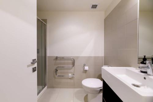 a bathroom with a toilet and a sink and a shower at Central Mount Apartment, Quiet and Spacious with Pool in Mount Maunganui