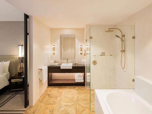 a bathroom with a tub and a sink and a shower at The William Inglis Mgallery in Warwick Farm