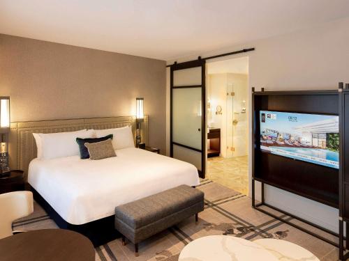 a hotel room with a bed and a flat screen tv at The William Inglis Mgallery in Warwick Farm