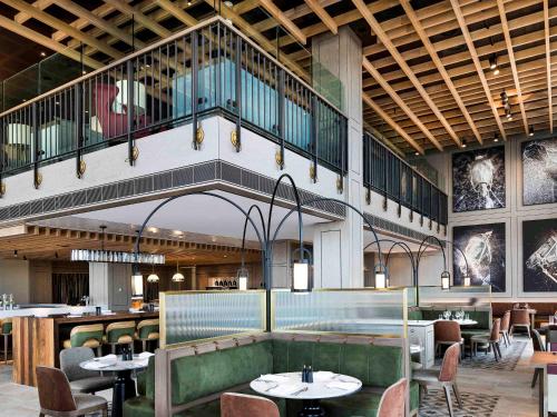 a restaurant with tables and chairs and a balcony at The William Inglis Mgallery in Warwick Farm