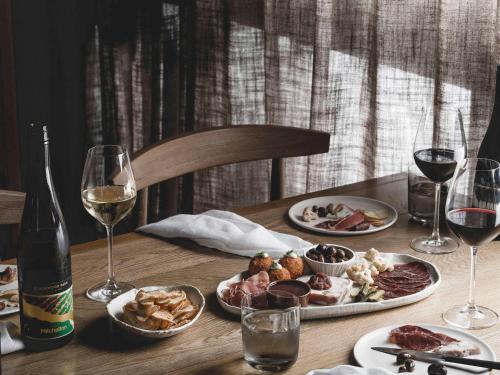 a table with plates of food and a bottle of wine at The Mitchelton Hotel Nagambie in Nagambie
