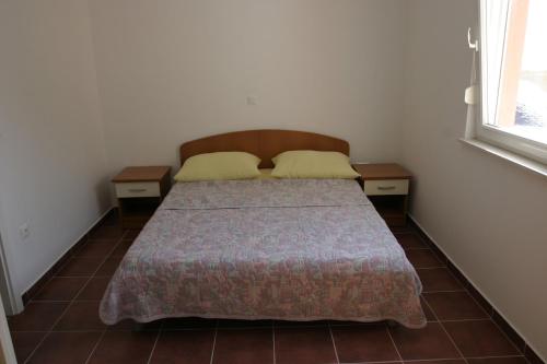 ein Schlafzimmer mit einem Bett mit zwei Nachttischen und einem Fenster in der Unterkunft Villa Nelo in Podaca