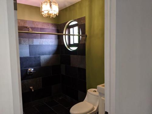 a bathroom with a toilet and a mirror at Villa Sulterra in Tambor