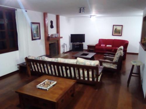 a living room with a couch and a table at Guest House Nosso Aconchego in Teresópolis
